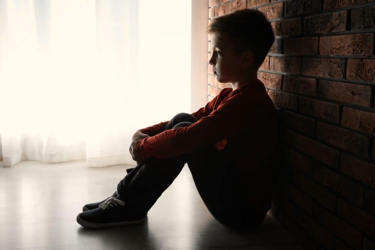Niño sentado representando heridas de infancia y dolor emocional