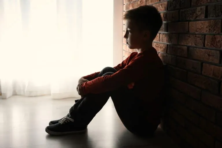 Niño sentado representando heridas de infancia y dolor emocional