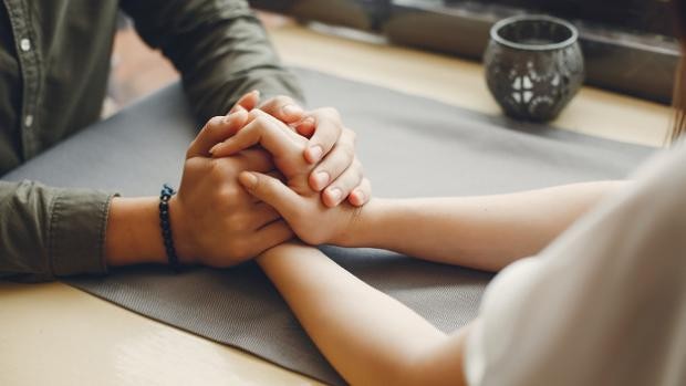 Pareja en sesión de terapia sosteniendo manos